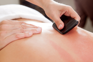guasha treatment massage with black hard stone